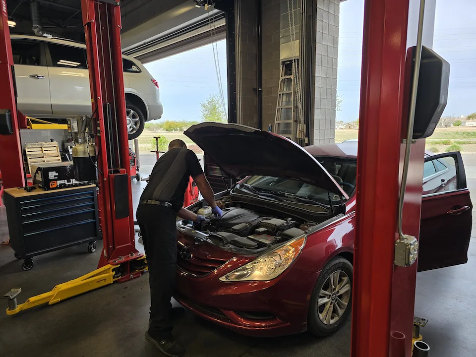 mechanic under hood of car in arizona